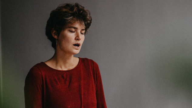 a woman sitting meditatively and making sounds